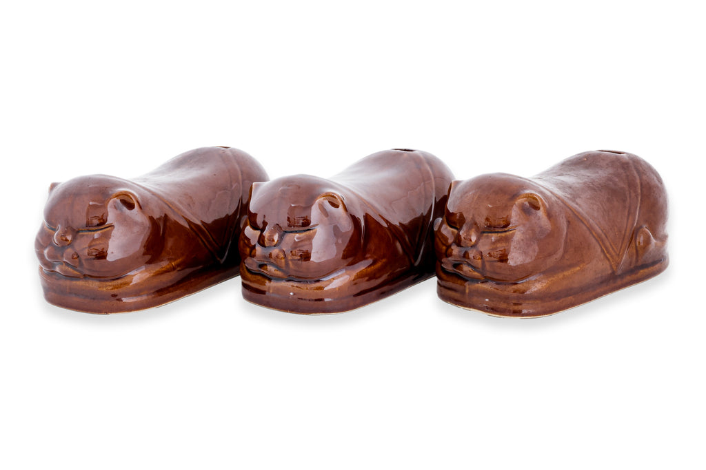 A GROUP OF THREE BROWN GLAZED CERAMIC PILLOW MONEY BOXES