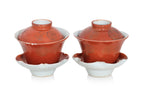 TWO SMALL CORAL GROUND TEA BOWLS WITH COVERS AND SAUCERS