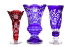 THREE LARGE COLOURED CUT TO CLEAR CRYSTAL VASES