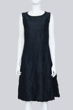 COMME DES GARÇONS TRICOT - A SLEEVELESS BLACK PANELLED DRESS WITH RUFFLED TRIM