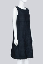 COMME DES GARÇONS TRICOT - A SLEEVELESS BLACK PANELLED DRESS WITH RUFFLED TRIM