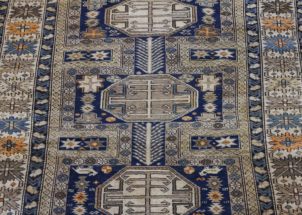 AN ANTIQUE CAUCASIAN WOOL RUG (165 X 125CM)