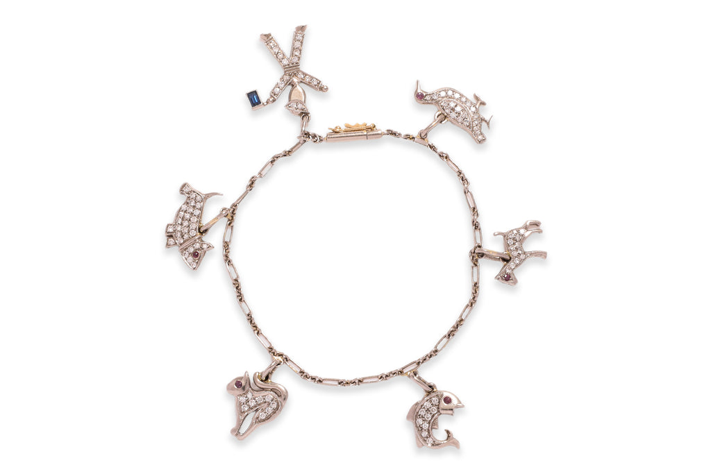 A CHARM BRACELET WITH ANIMAL AND FIGURATIVE CHARMS