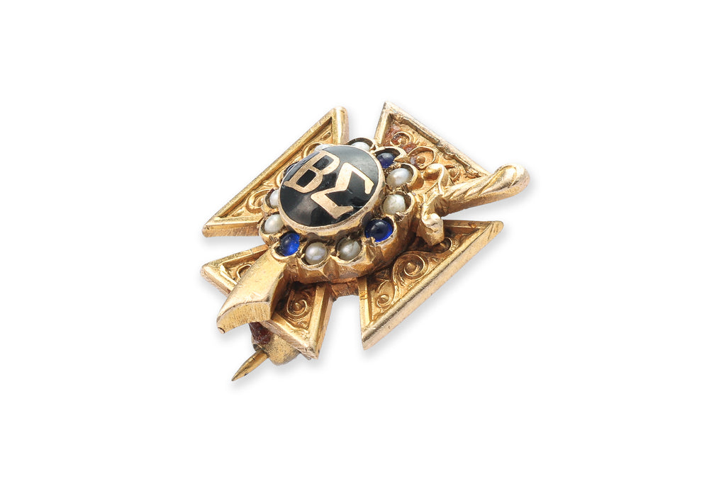 A GOLD SORORITY BADGE