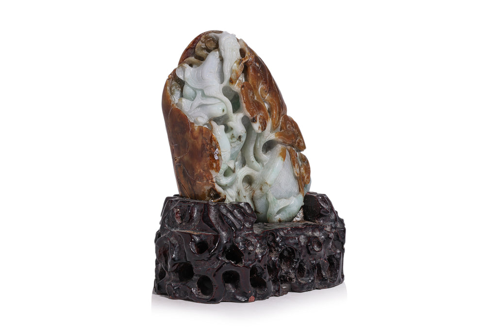 A CARVED GREEN AND RUSSET JADEITE BOULDER