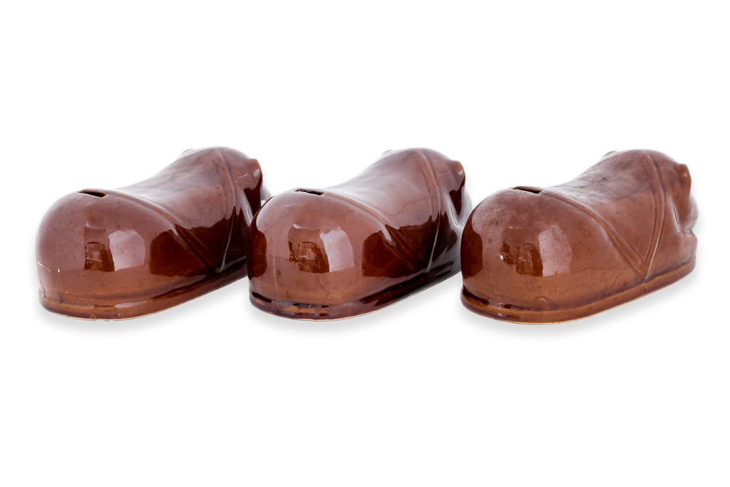 A GROUP OF THREE BROWN GLAZED CERAMIC PILLOW MONEY BOXES