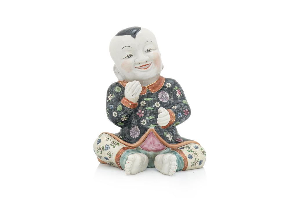 A CHINESE CERAMIC FIGURE OF A SEATED BOY
