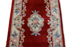 A CHINESE RED FLORAL WOOL HALL RUNNER (69 X 244CM)