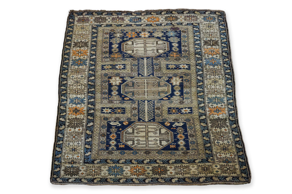AN ANTIQUE CAUCASIAN WOOL RUG (165 X 125CM)