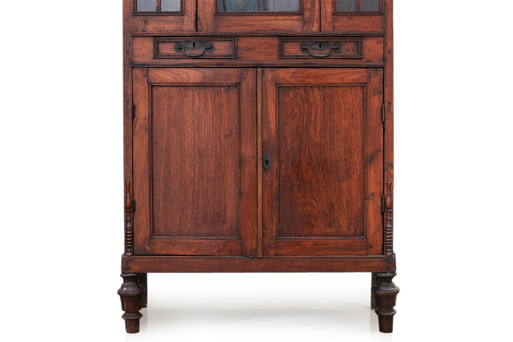 A SMALL GLAZED TEAK CABINET