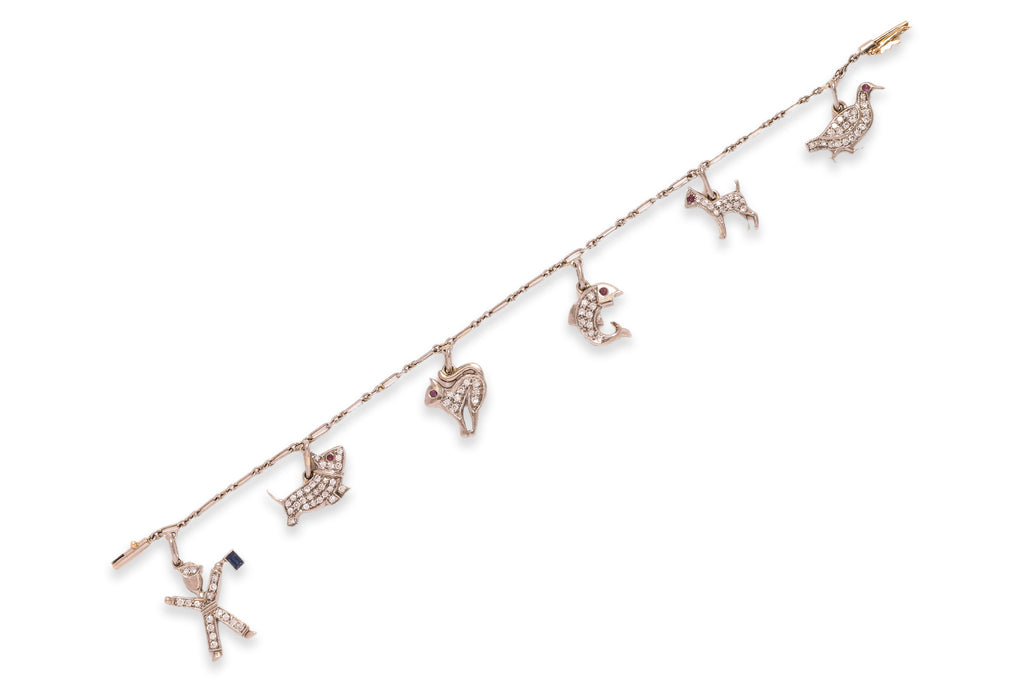 A CHARM BRACELET WITH ANIMAL AND FIGURATIVE CHARMS