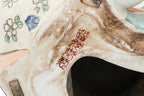 A CHINESE CERAMIC FIGURE OF A SEATED BOY